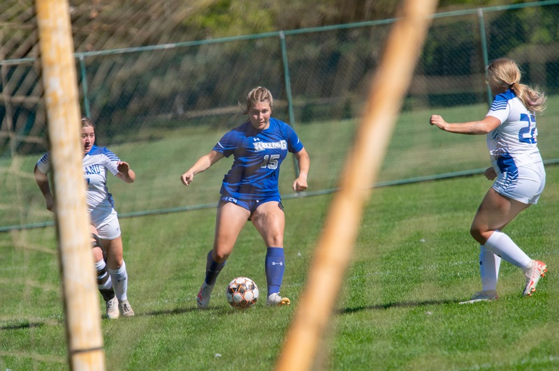 Women's soccer players compete during a home game.